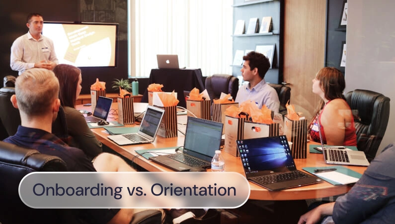 A group of people around a large desk in a meeting room, with the label: Onboarding vs Orientation